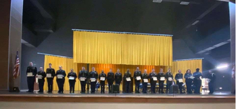 JROTC cadets line up across the stage of the Athens Performing Arts Center (APAC) displaying their certificates. “Our cadets earn either National Awards provided by organizations such as the 101st Airborne Division Association  and the Association of the United States Army (AUSA), or  Local Awards such as the Personal Appearance Ribbon. All of these awards become part of the cadets permanent uniform and they can be observed wearing them on the left side of  their uniform with pride!” Chief Chambers said.